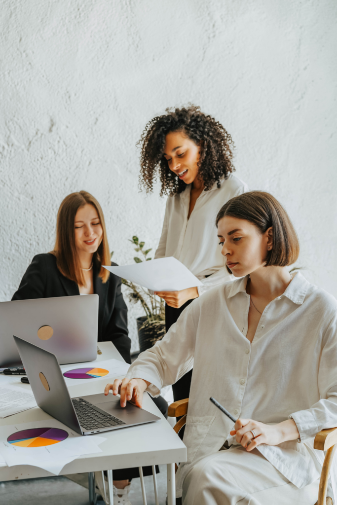 Group of women at a desk working together.