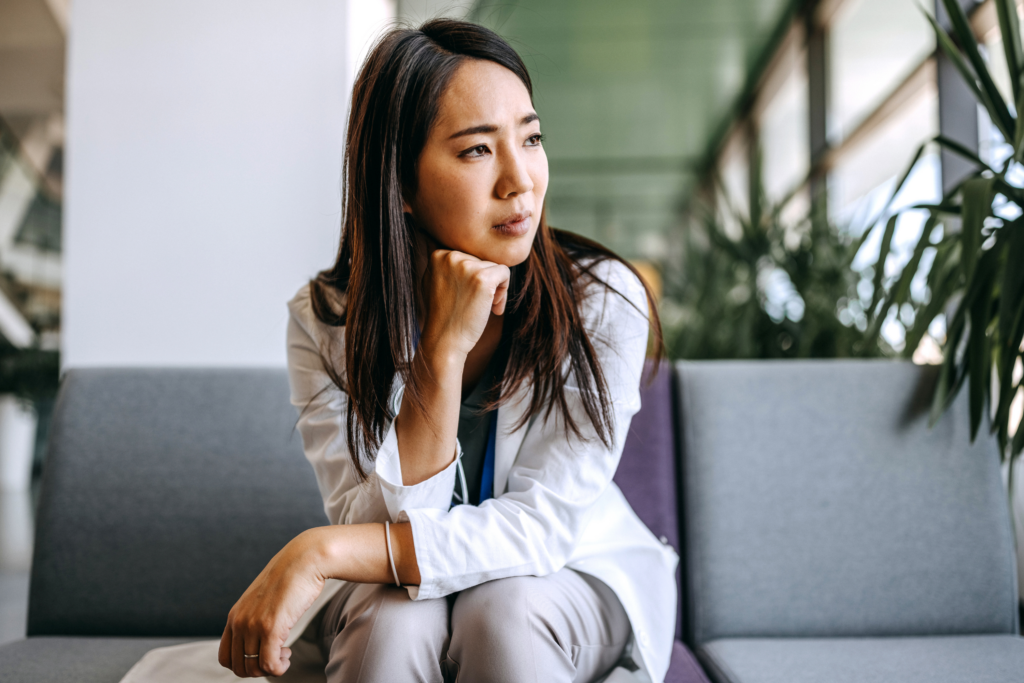 Woman sitting looking away from the camera looking sad.