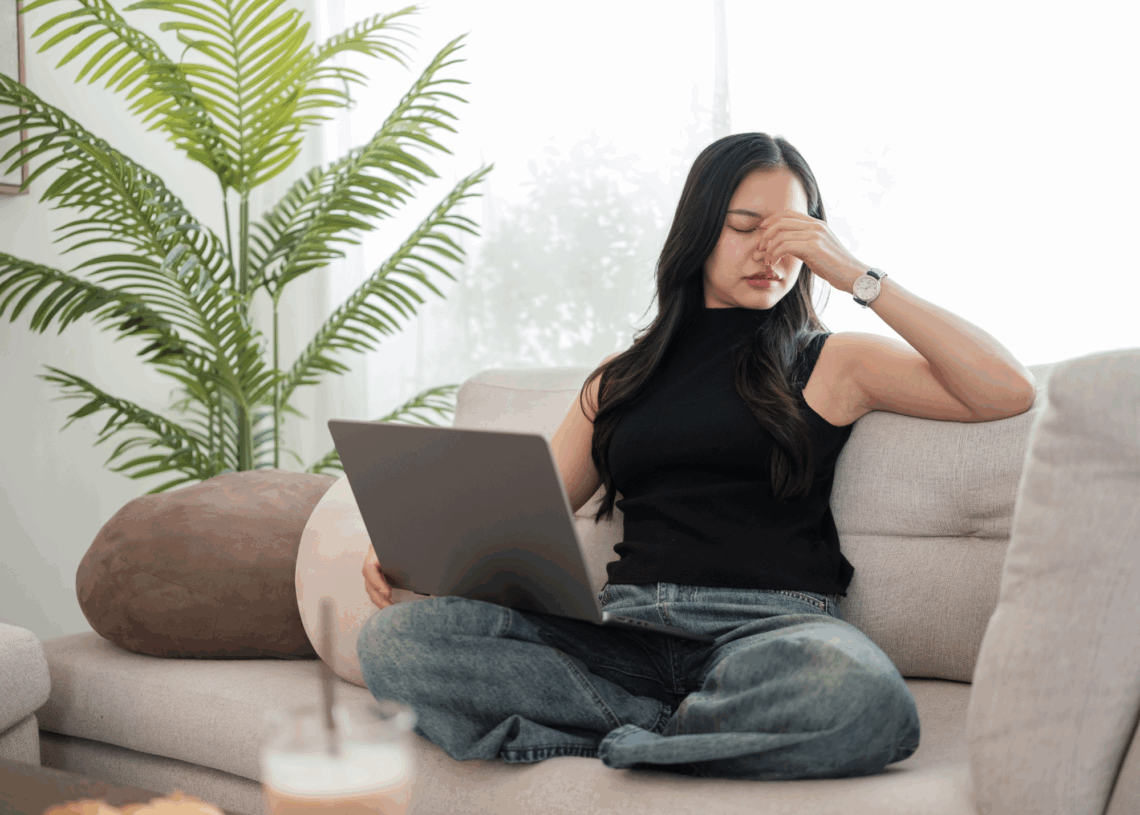 Frustrated women on a couch with laptop