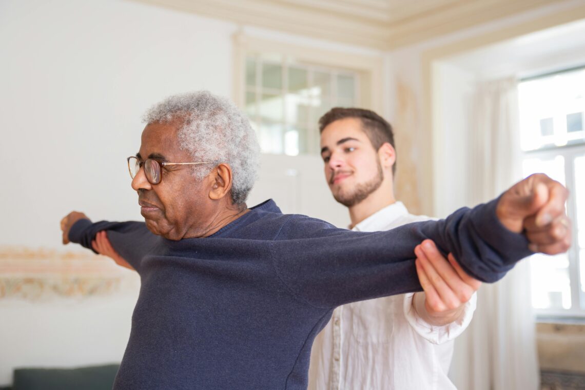 Young attendant doing mobility exercises with senior